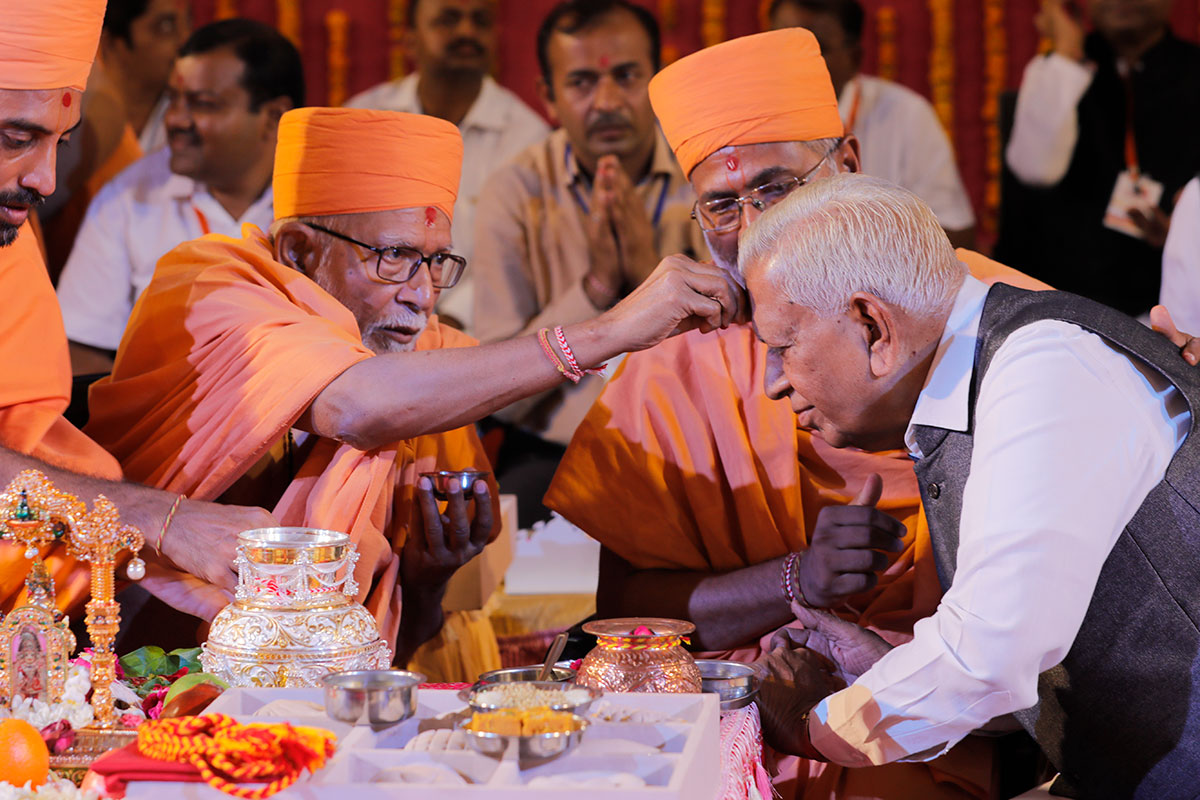 Pujya Kothari Swami applies chandlo to Shri Vajubhai Vala (Governor of Karnataka)