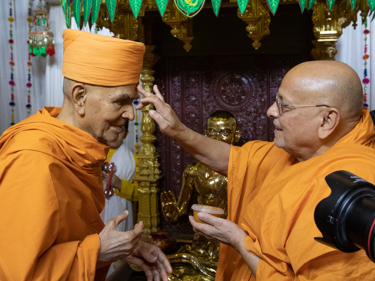 Pujya Ishwarcharan Swami applies chandlo to Swamishri