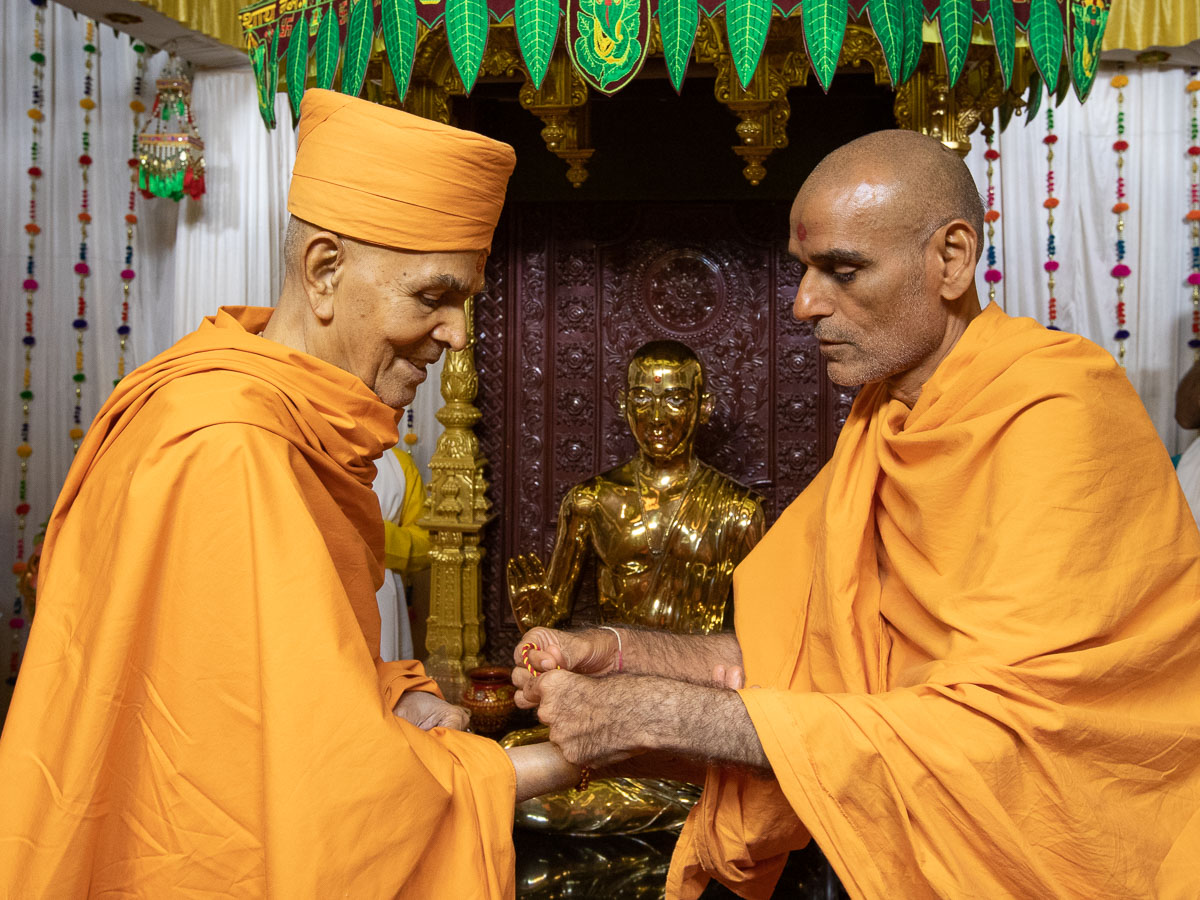 Anandswarup Swami ties a nadachhadi to Swamishri