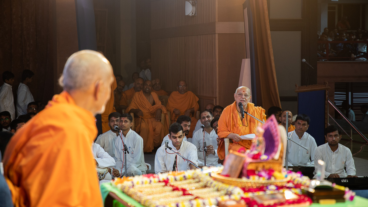 Pujya Ishwarcharan Swami sings a kirtan in Swamishri's puja