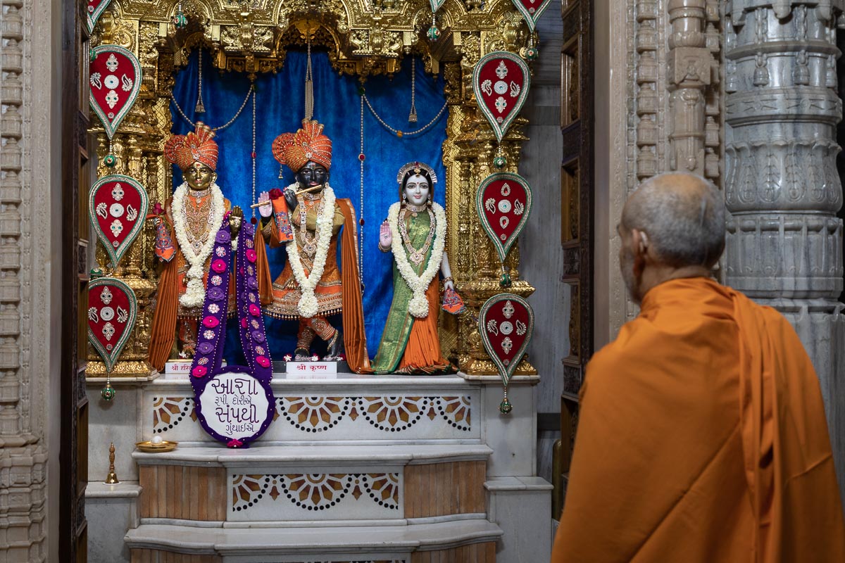 Swamishri engrossed in darshan of Shri Harikrishna Maharaj and Shri Radha-Krishna Dev