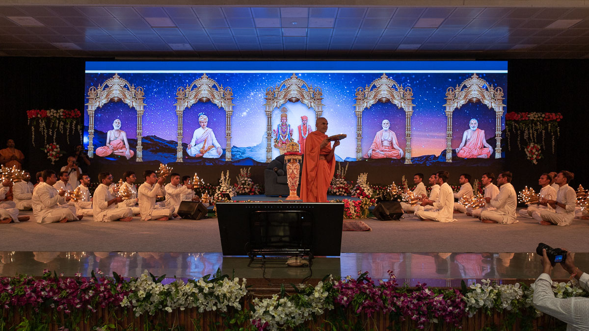 Swamishri and karyakars perform the evening arti
