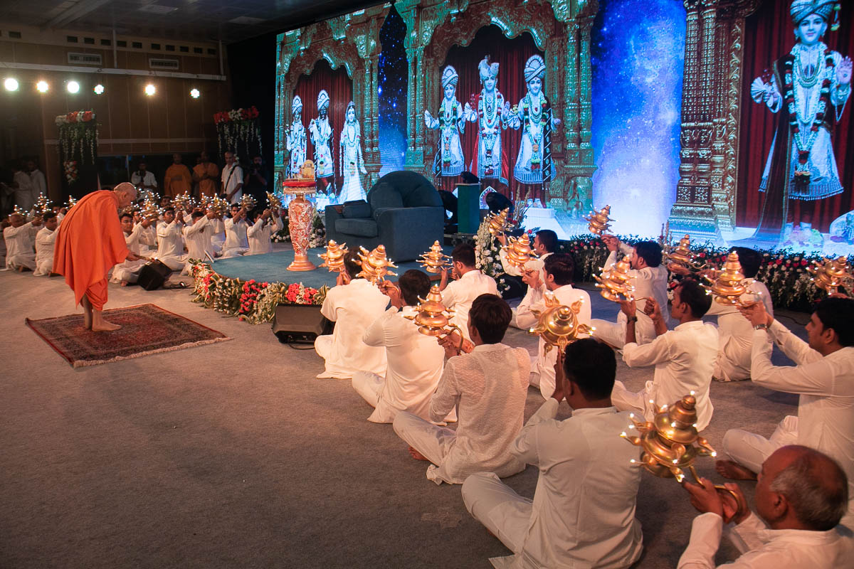 Swamishri and karyakars perform the evening arti