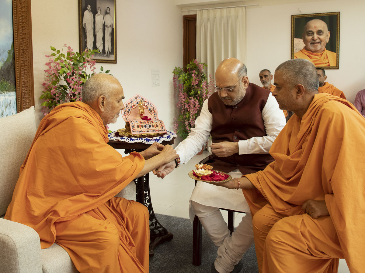 Swamishri ties a nadachhadi to Shri Amit Shah