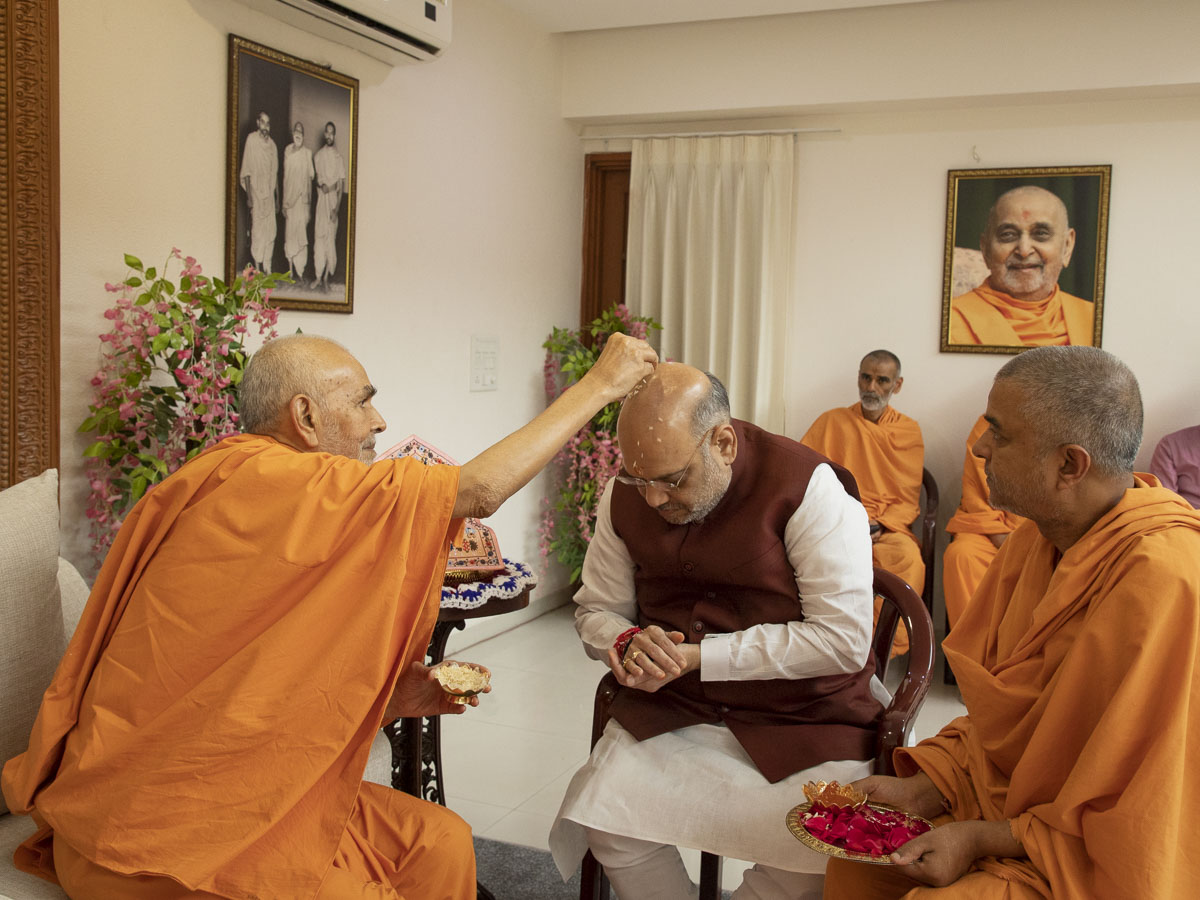 Swamishri showers sanctified akshat (rice grains) on Shri Amit Shah