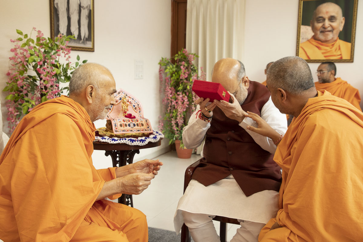 Swamishri presents a holy relic in memory of Pramukh Swami Maharaj to Shri Amit Shah