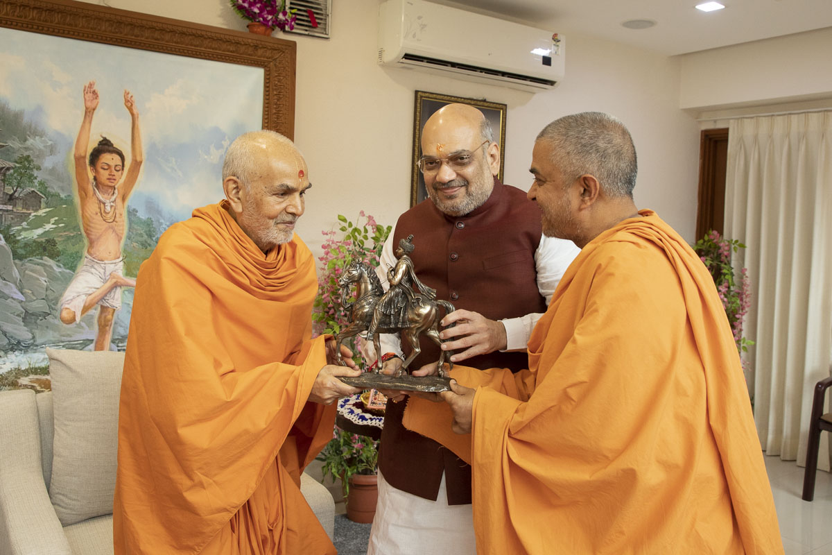 Swamishri presents a model of Bhagwan Swaminarayan on his horse Rojho to Shri Amit Shah to mark the auspicious day of Rathyatra
