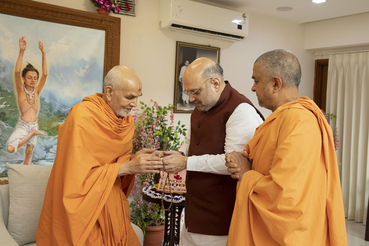 Swamishri presents a mala to Shri Amit Shah