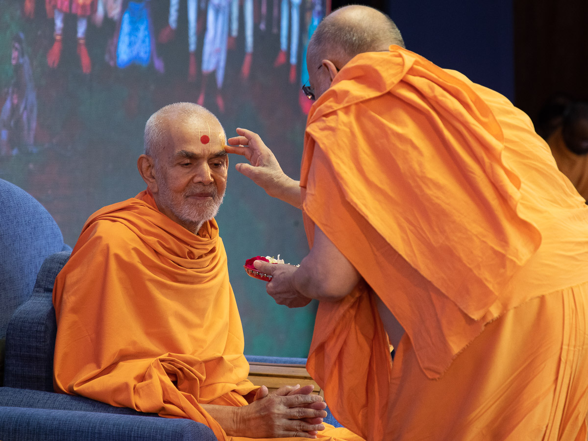 Pujya Ishwarcharan Swami applies archa to Swamishri