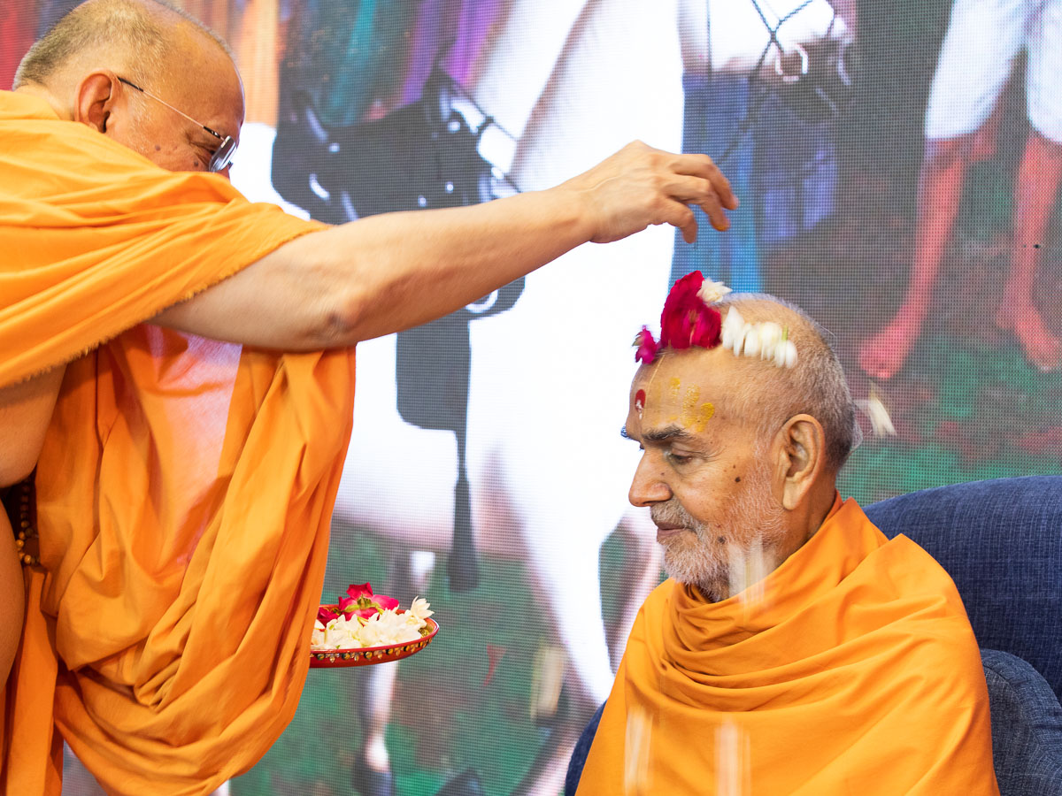 Pujya Ishwarcharan Swami showers flowers on Swamishri