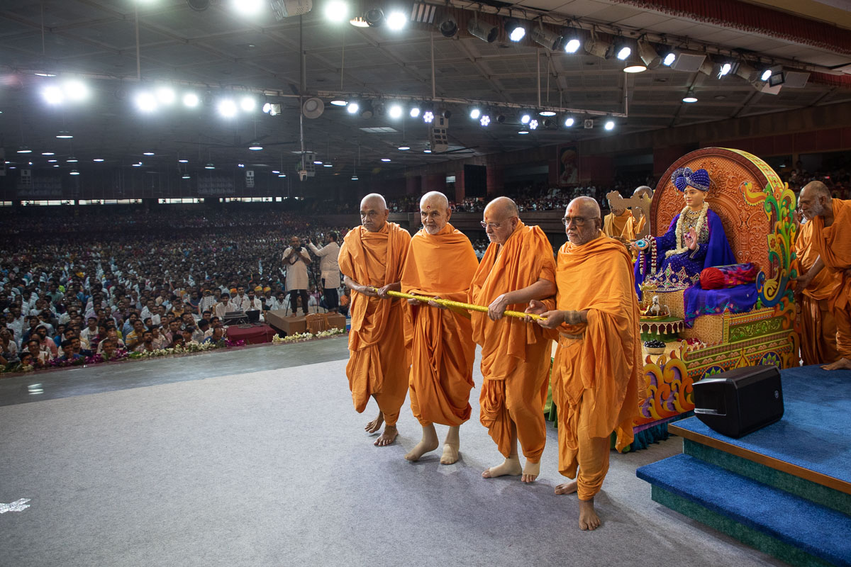 Swamishri, Pujya Ishwarcharan Swami and sadhus pull the chariot of Shri Harikrishna Maharaj and Bhagwan Swaminarayan