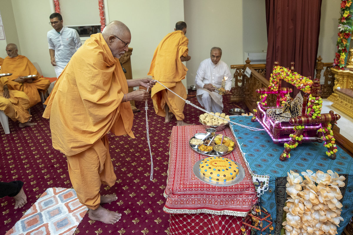 Pujya Kothari Swami swings Shri Harikrishna Maharaj in a hindolo