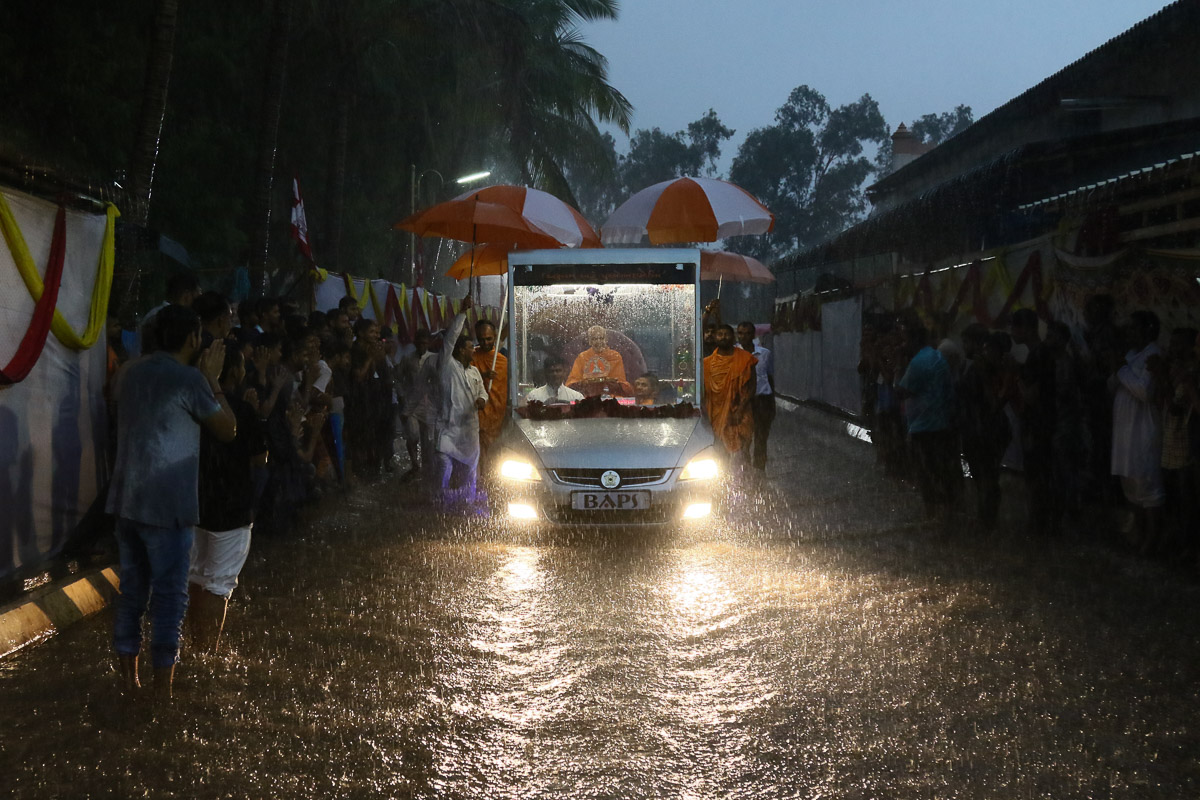 Amidst heavy rain, Swamishri on his way to the evening satsang assembly