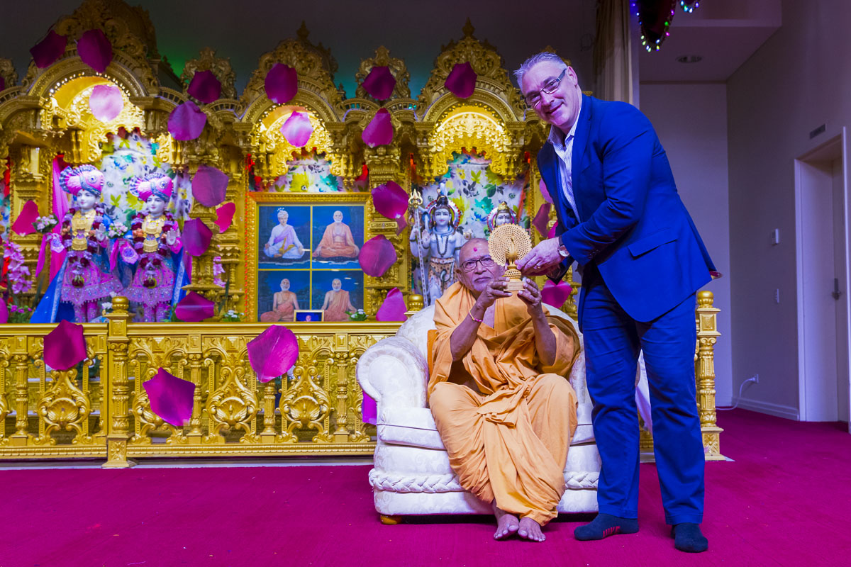 Pujya Kothari Swami presents a memento to an invited guest