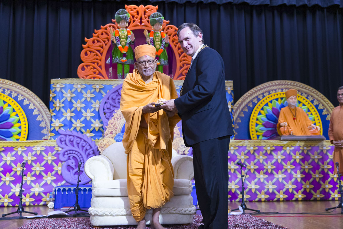 Pujya Kothari Swami presents a memento to an invited guest
