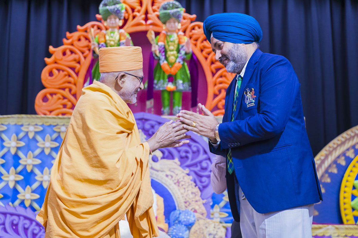 Pujya Kothari Swami greets an invited guest with 'Jai Swaminarayan'