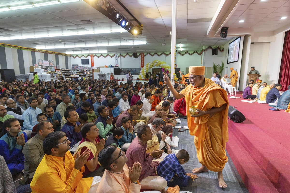 Pujya Kothari Swami showers akshat (rice grains) on devotees
