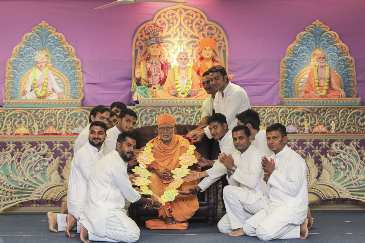 Devotees welcome Pujya Kothari Swami with a garland