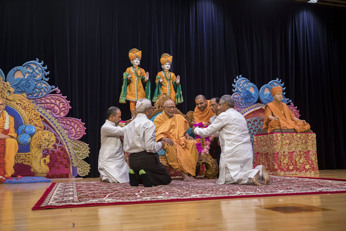 Devotees welcome Pujya Kothari Swami with a garland