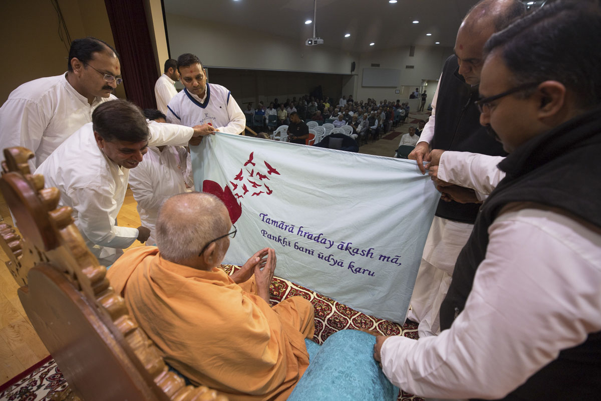 Pujya Kothari Swami observes a shawl