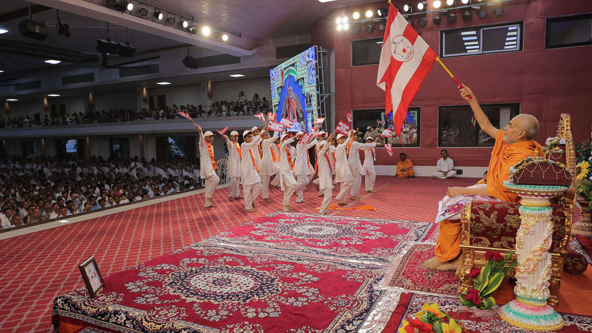 Swamishri and children wave BAPS flags