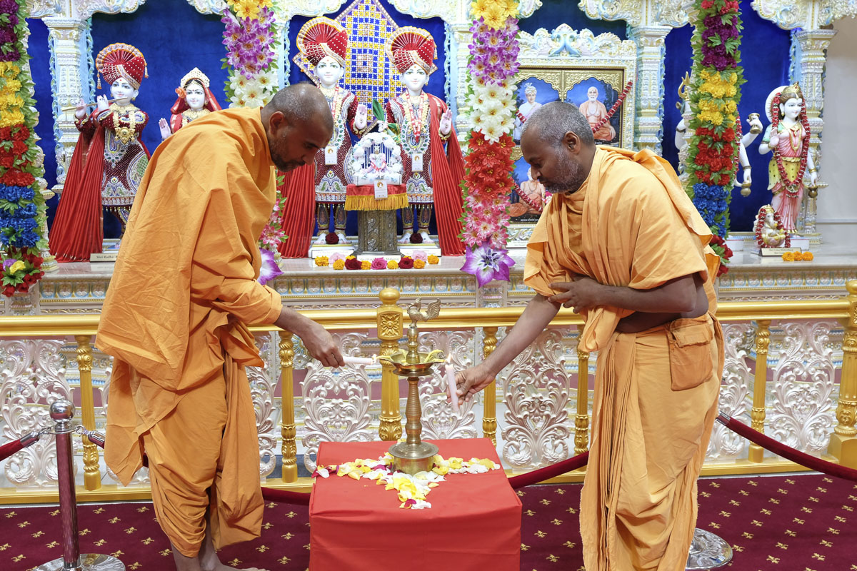 Paramchintan Swami and Akhandmangal Swami light the inaugural lamp (deep-pragatya)
