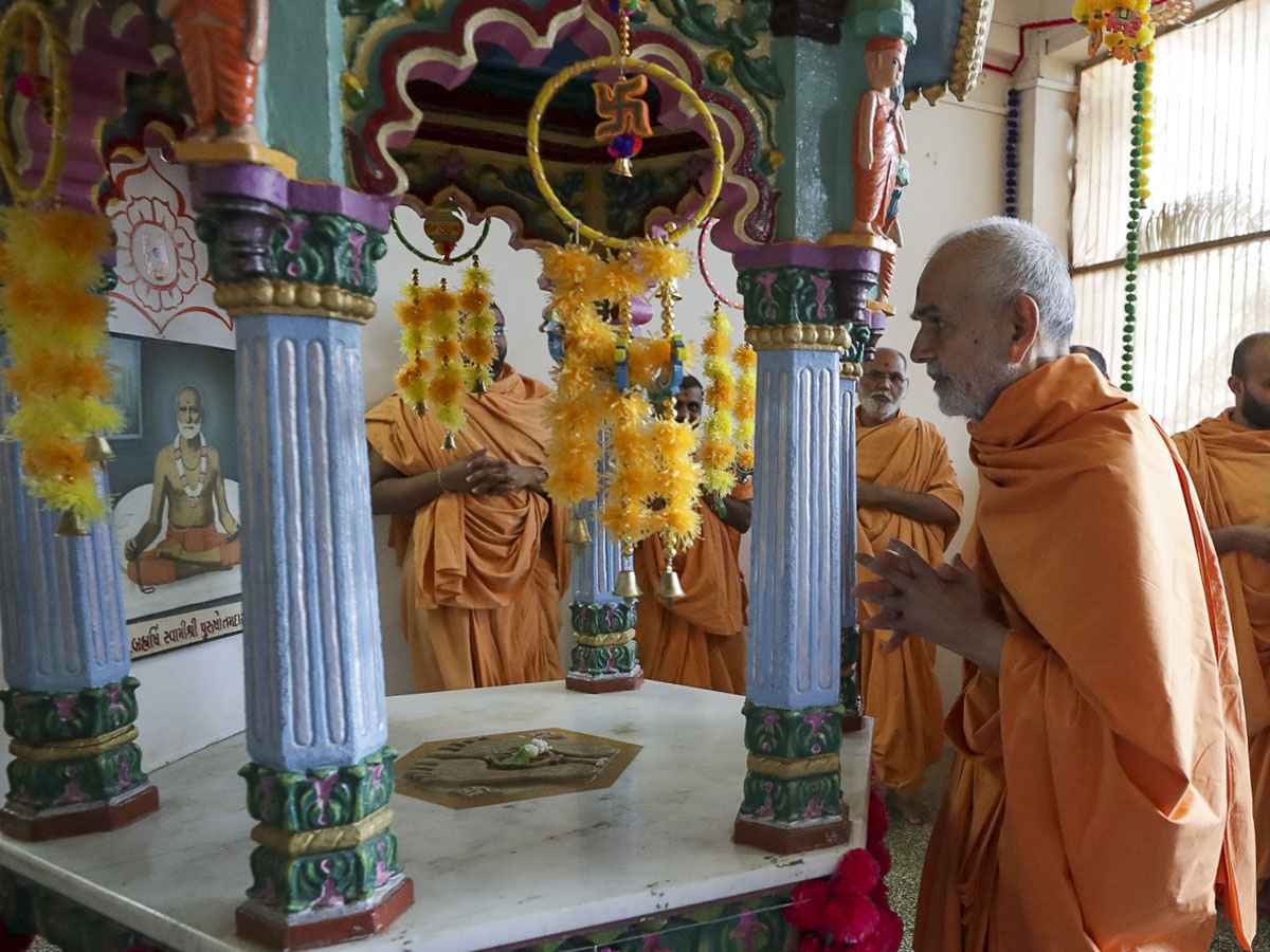 Swamishri engrossed in darshan at the shrine of Purushottamdas Swami (Khandeshi)