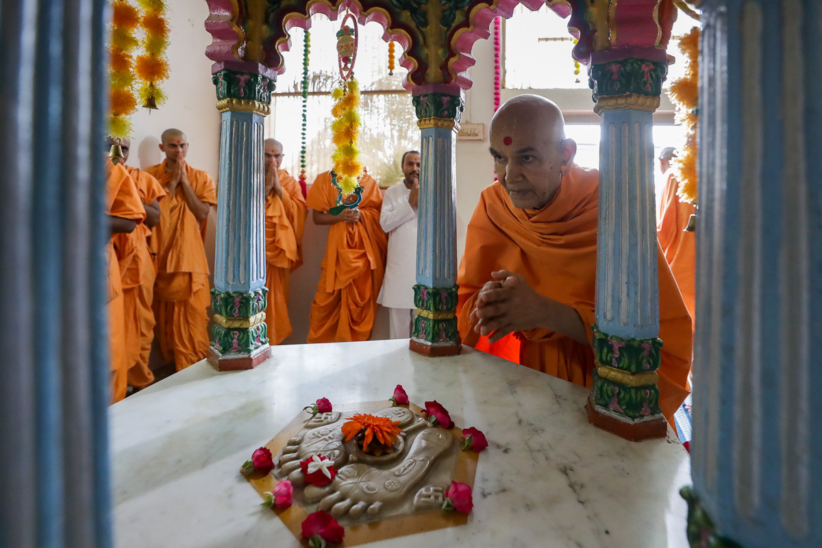 Swamishri engrossed in darshan at the shrine of Purushottamdas Swami (Khandeshi)