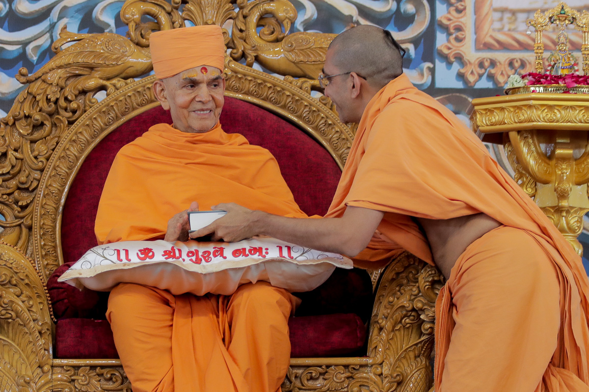 Swamishri blesses Adarshjivan Swami, author of the biography