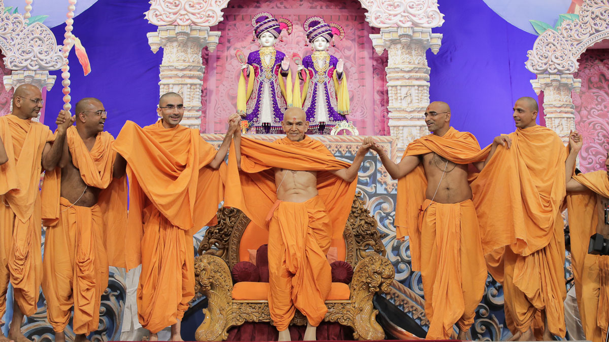 Swamishri and sadhus join hands in a gesture of unity