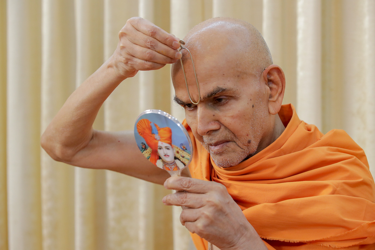 Param Pujya Mahant Swami Maharaj applies tilak on his forehead