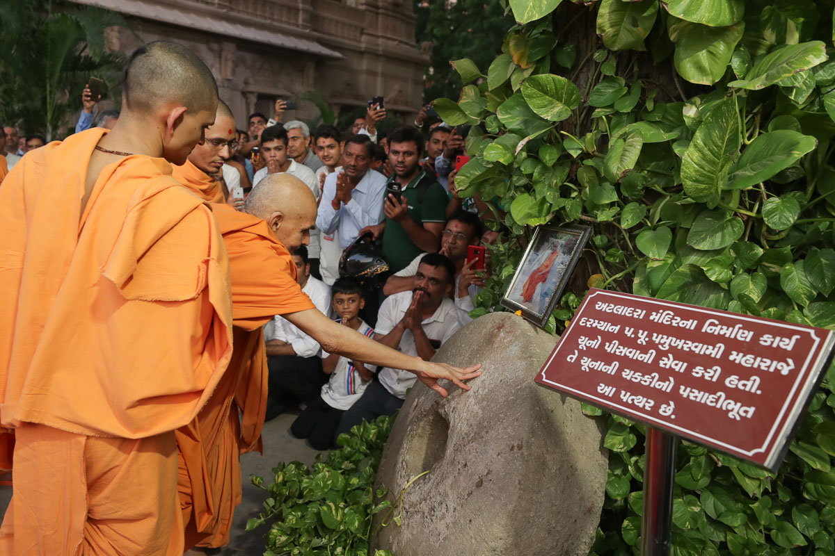 Swamishri reverentially touches a sanctified stone used by Brahmaswarup Pramukh Swami Maharaj to prepare limestone during the construction of Atladra mandir