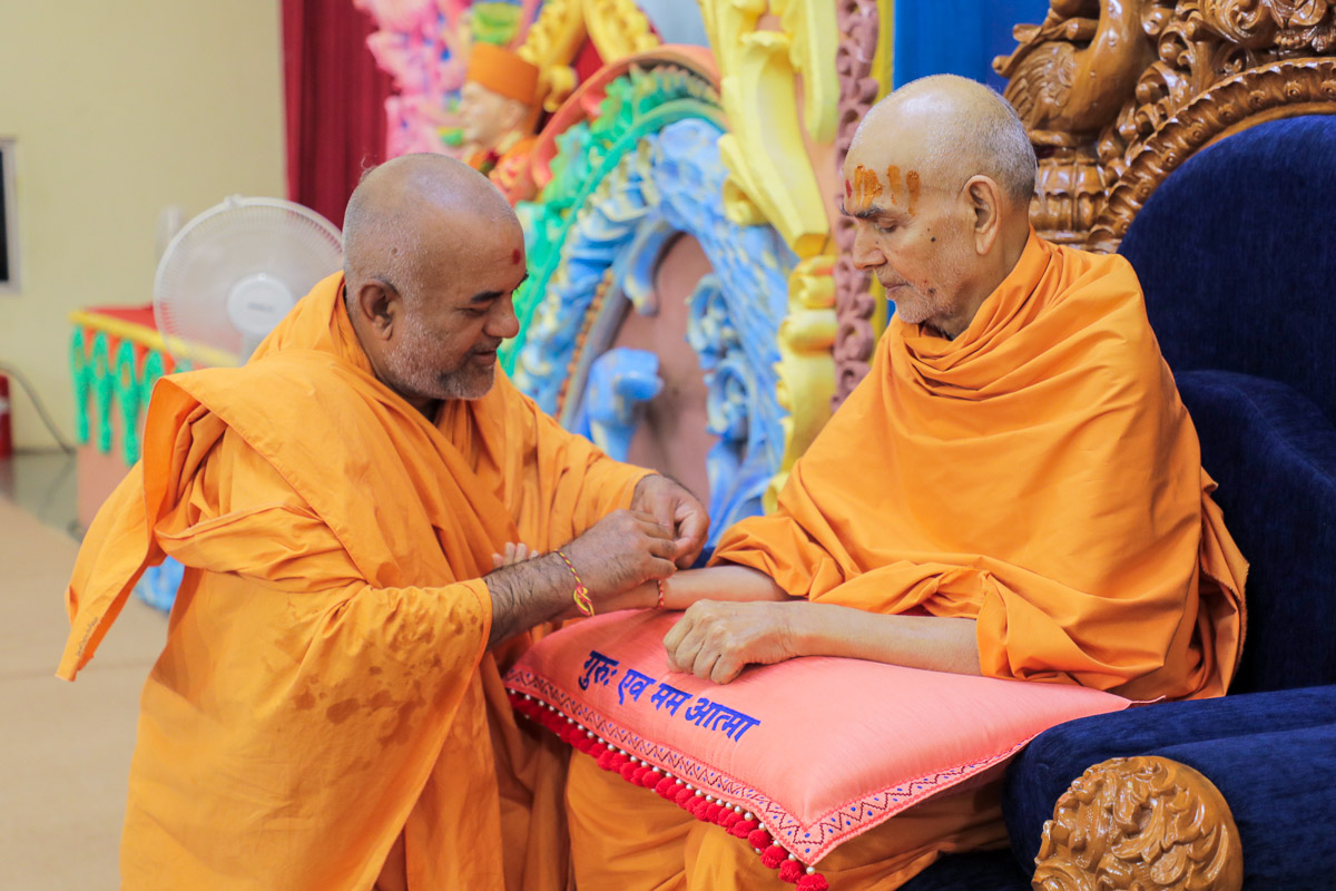 Bhagyasetu Swami ties a nadachhadi to Swamishri