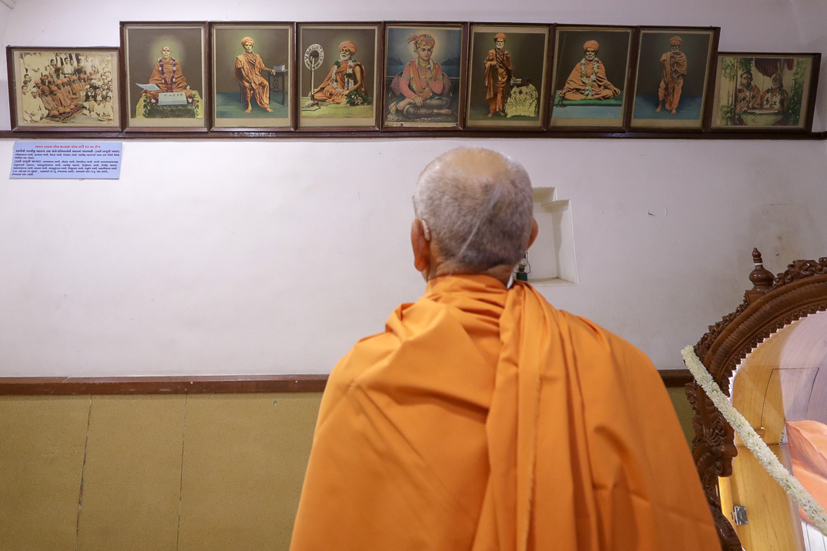 Swamishri observes photos of Brahmaswarup Shastriji Maharaj