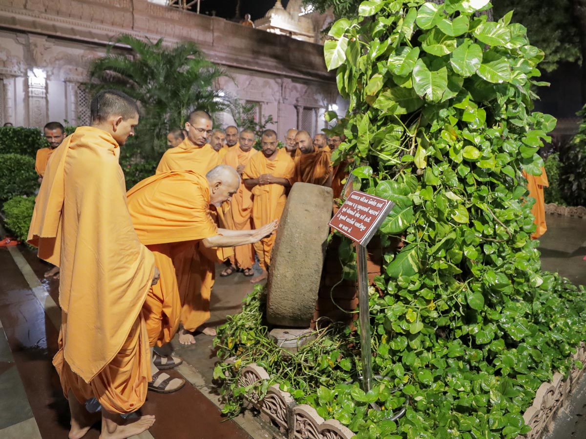 Swamishri reverentially touches a sanctified stone used by Brahmaswarup Pramukh Swami Maharaj to prepare limestone during the construction of Atladra mandir