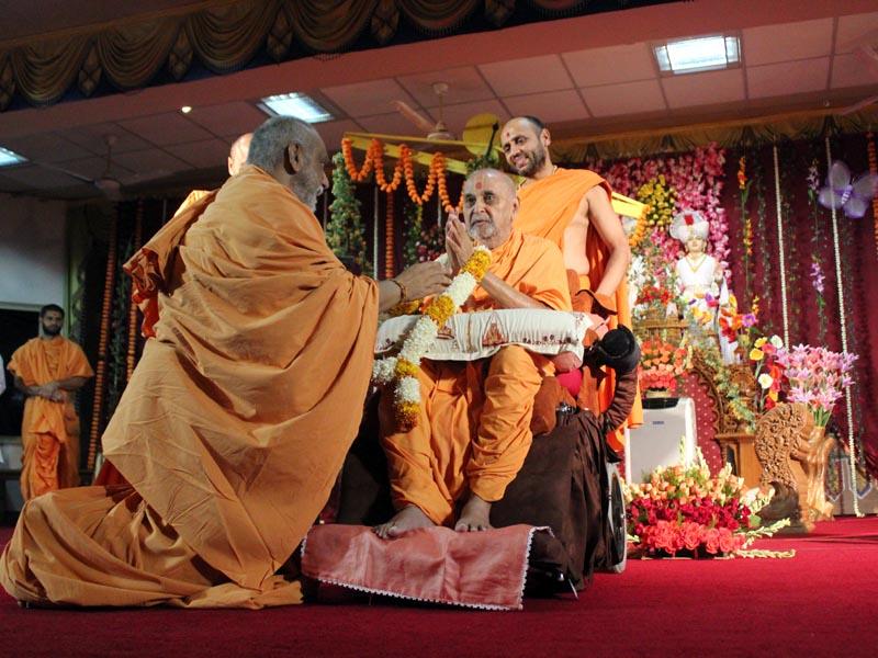  Pujya Atmaswarup Swami honors Swamishri with a garland