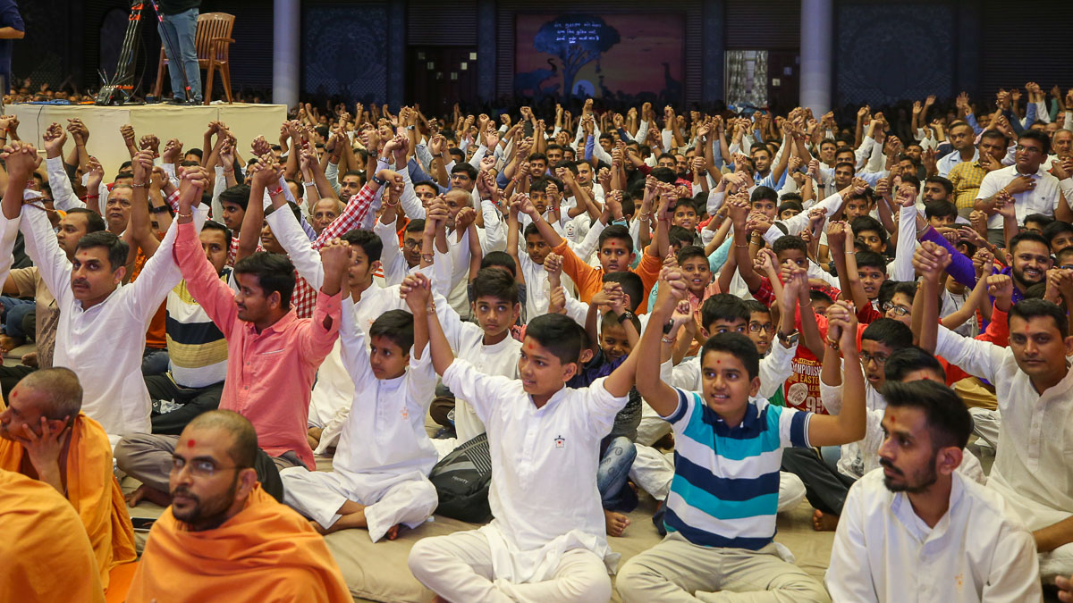 Children and devotees join hands in a gesture of unity