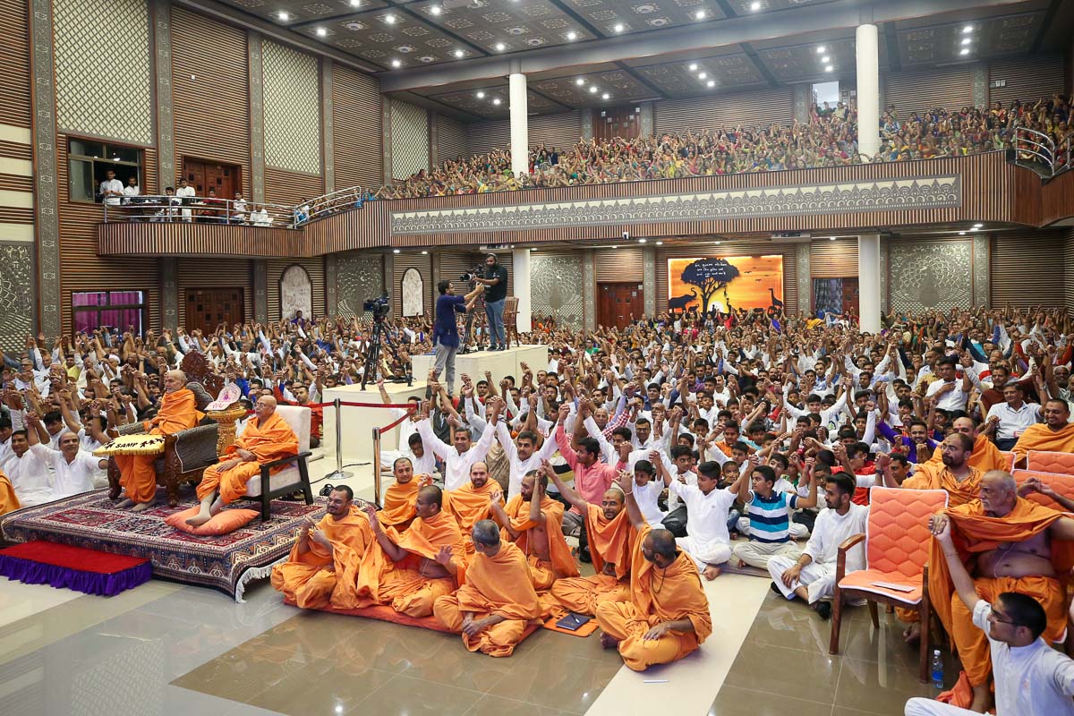 Sadhus, children and devotees join hands in a gesture of unity