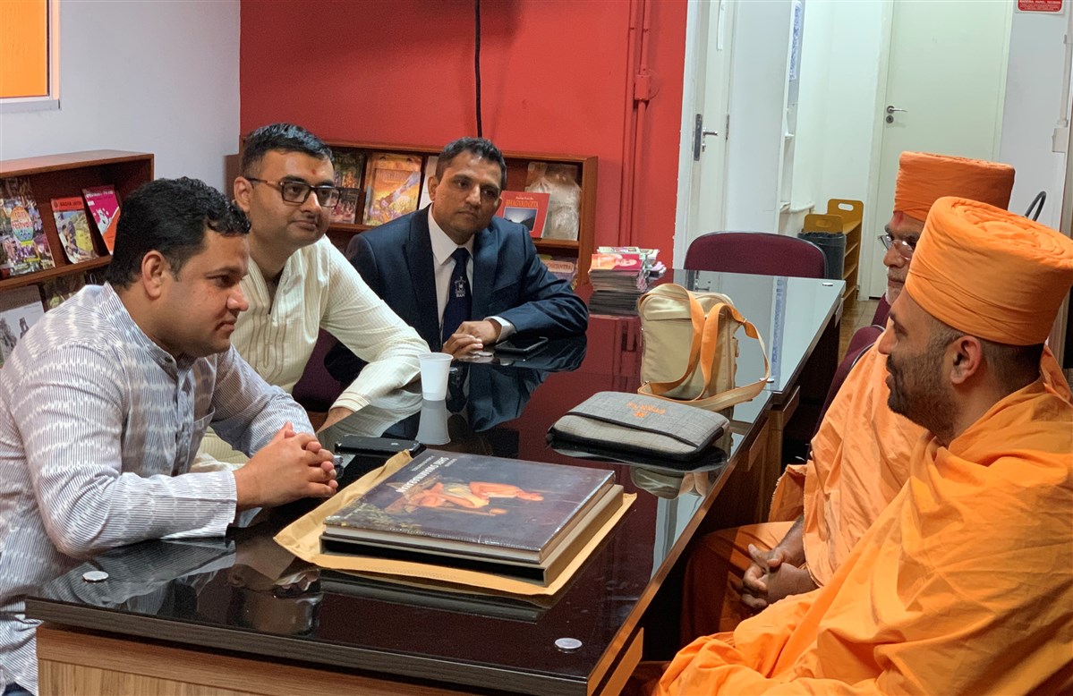 The Hon'ble Mr. Amit Kumar Mishra, Consul General of India and the BAPS delegation in the meeting hall