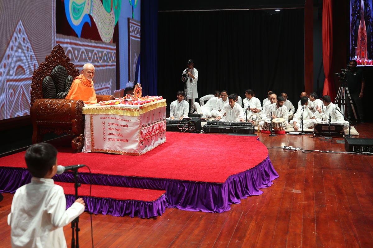 Swamishri listens to a child's recitations
