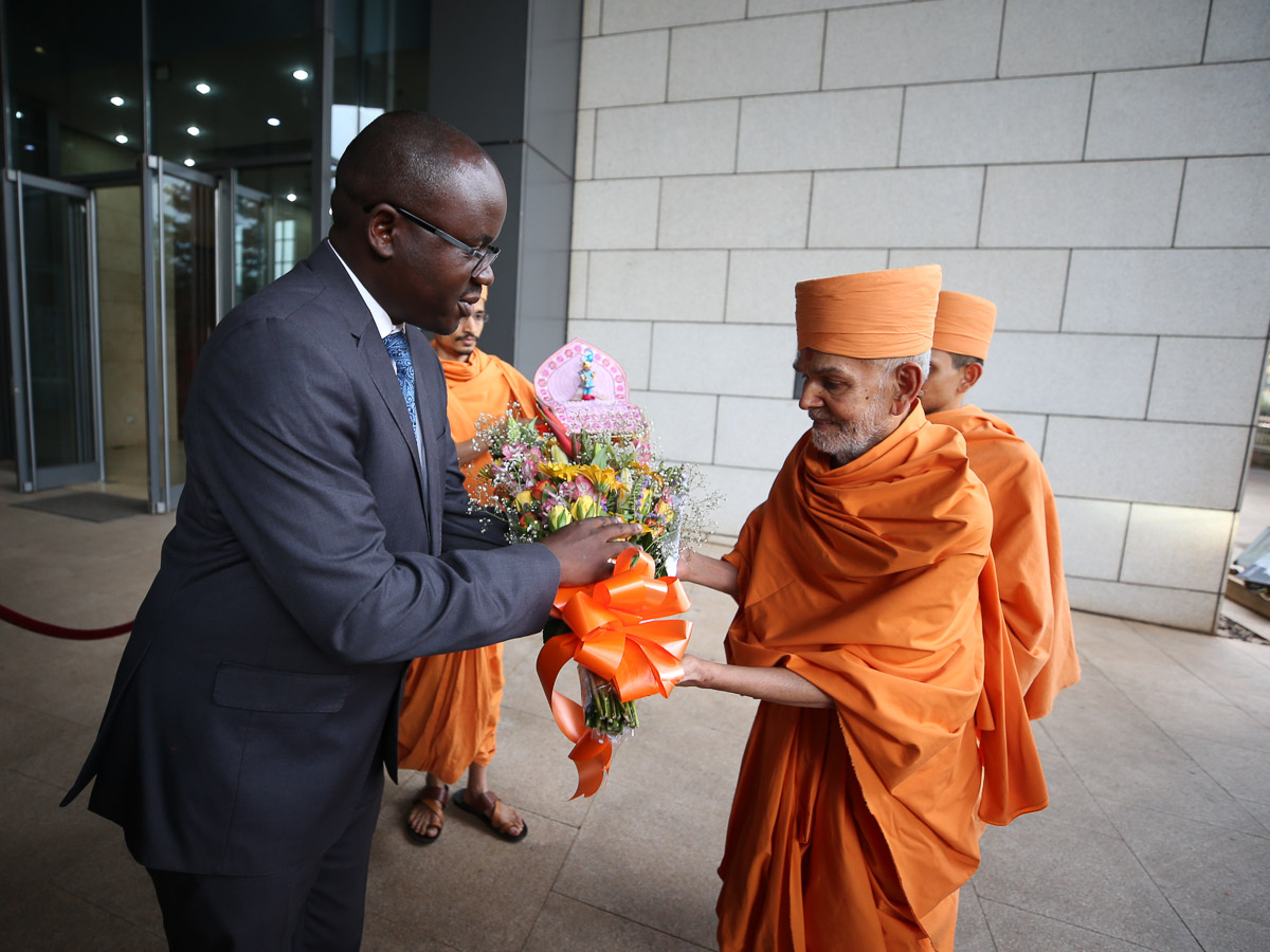 An official greets Swamishri at the Office of the Prime Minister of Uganda