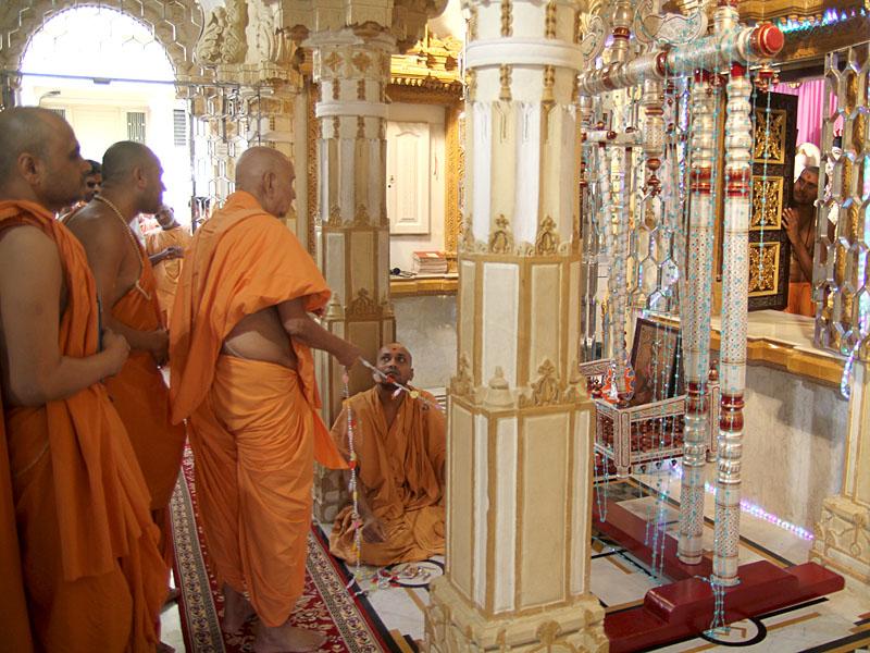  Swamishri swings Shri Harikrishna Maharaj in a decorative hindolo