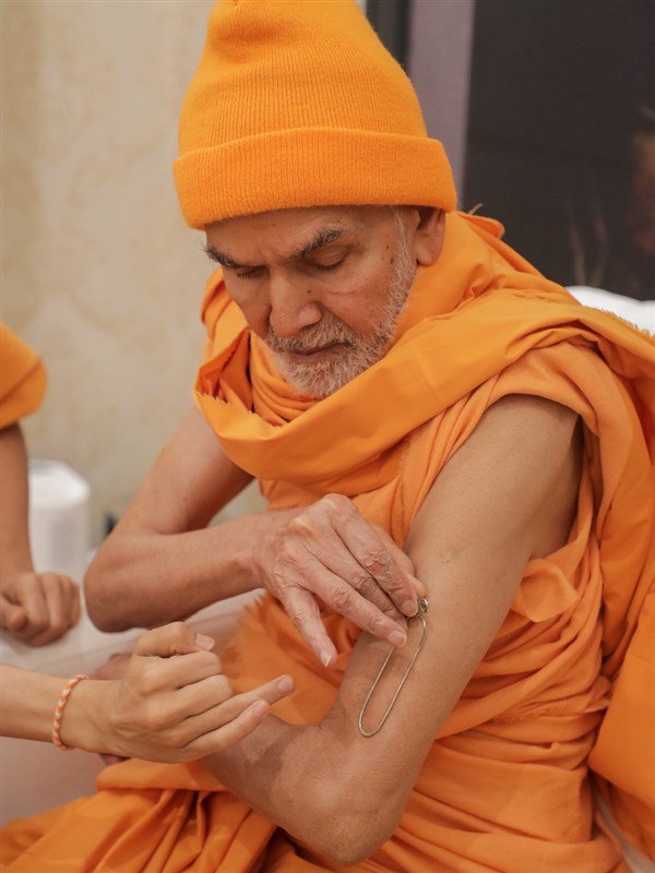 Param Pujya Mahant Swami Maharaj applies tilak on his upper arm