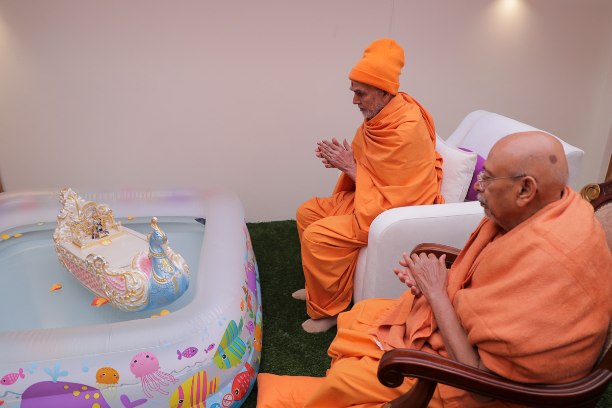 Swamishri and Pujya Tyagvallabh Swami engrossed in darshan of Shri Harikrishna Maharaj