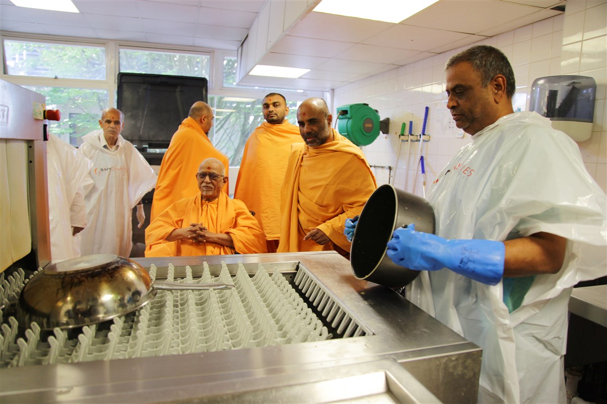 Pujya Doctor Swami is taken on a guided tour of the kitchen