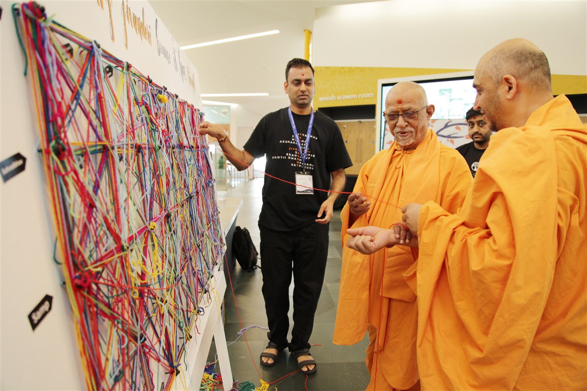Pujya Doctor Swami interacts with a learning station for delegates