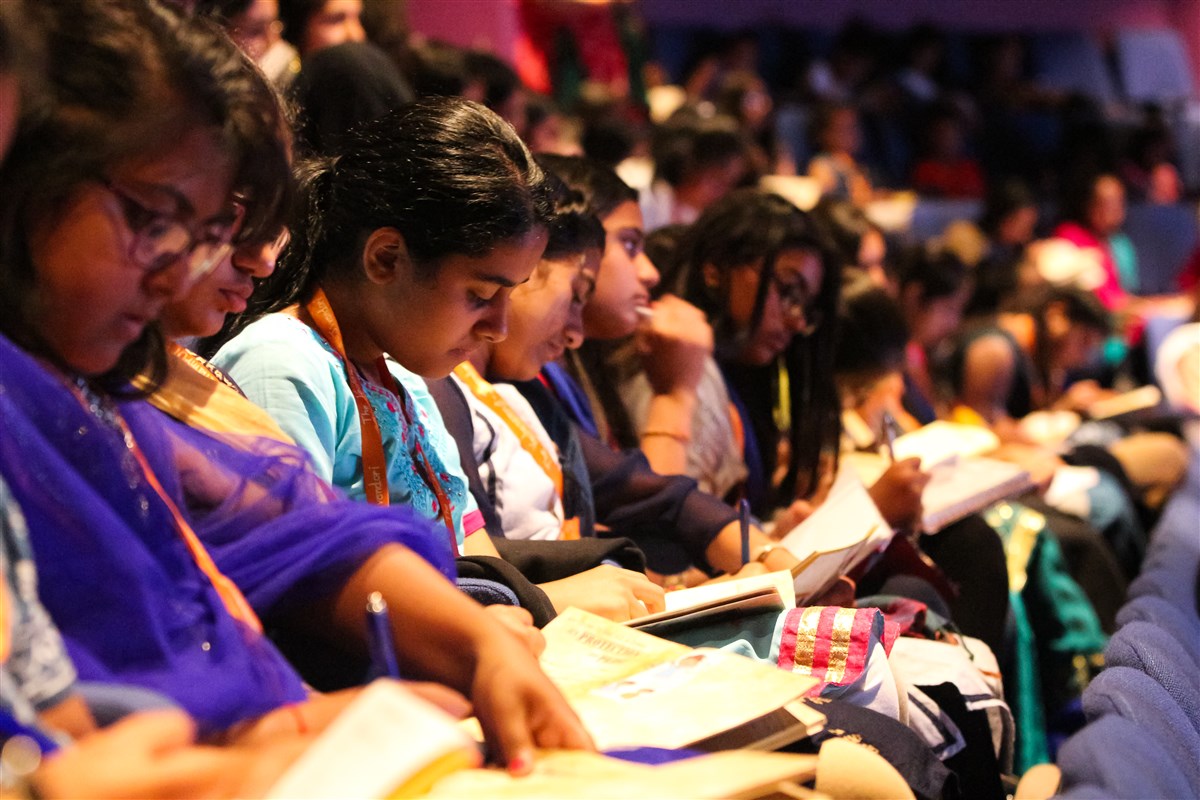 Delegates take notes in their thematic notebook whilst listening attentively