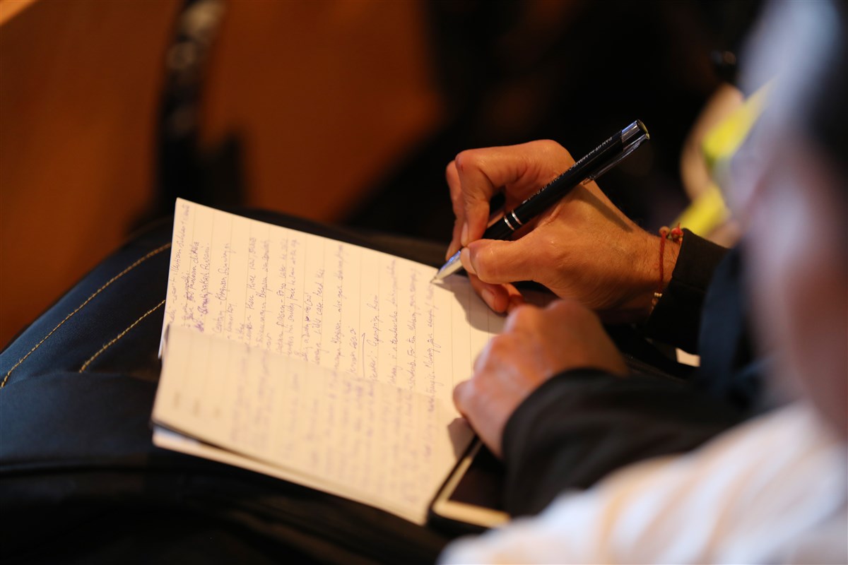 A delegate takes notes during the session