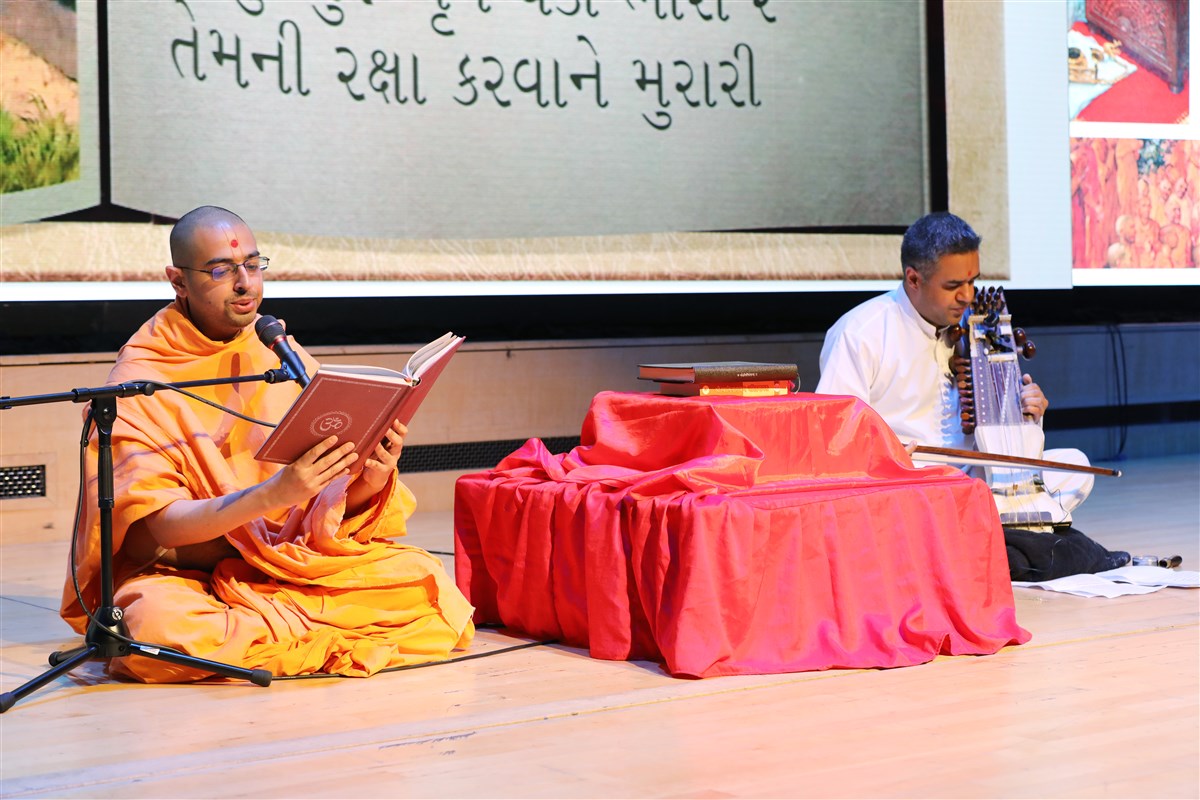 Gurukirtan Swami is accompanied by a youth playing the sarangi