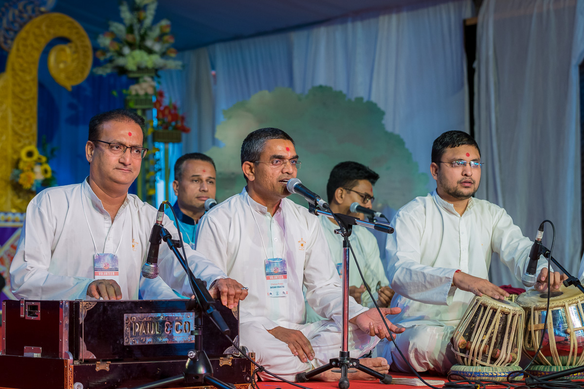 Youths sing kirtans in the evening welcome assembly